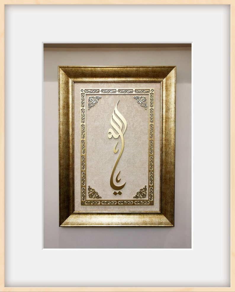 K&ouml;nnte beinhalten: Ein goldfarbener Bilderrahmen mit beigefarbenem Hintergrund und einem goldenen arabischen Kalligraphie-Design.