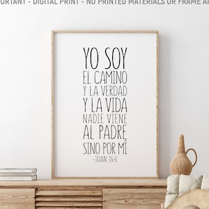 Può includere: Una stampa d'arte da parete stampabile in bianco e nero con il testo in spagnolo "Yo soy el camino y la verdad y la vida nadie viene al padre sino por mi -Juan 14:6". La stampa è incorniciata e appesa a una parete in una stanza con una sedia di legno e un tavolo di legno.