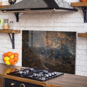 May include: A white ceramic mug with a black handle and the text "But First, Coffee" in a bold, black font. The mug is set against a blurred background, suggesting a cozy setting.