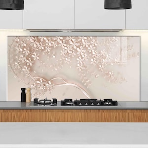 May include: A rectangular kitchen backsplash panel featuring a soft beige background with a 3D-effect illustration of delicate, light pink floral branches and leaves. The design displays a flowing, curved vine pattern with scattered blossoms.