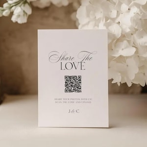 May include: A rectangular white card featuring the black text Share The LOVE in a mix of script and serif fonts. Below the text is a black and white QR code, followed by the instruction SHARE YOUR PHOTOS WITH US! SCAN THE CODE AND UPLOAD and J & C.