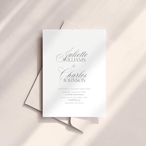 May include: A white wedding invitation with elegant script text. The invitation reads "Juliette Williams & Charles Johnson" and includes details about the wedding date, time, and location. The invitation is on a light beige background.