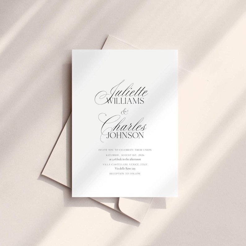 May include: A white wedding invitation with elegant script text. The invitation reads "Juliette Williams & Charles Johnson" and includes details about the wedding date, time, and location. The invitation is on a light beige background.