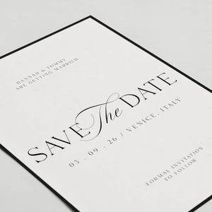 May include: A formal wedding invitation with a black border. The text "SAVE THE DATE" is prominently displayed in elegant black script. Additional text includes the names "HANNAH & TOMMY", the date "03.09.26", and the location "VENICE, ITALY".