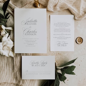 May include: Elegant wedding invitation suite with calligraphy text. The main invitation card features the names Juliette Williams & Charles Johnson. Additional cards include ceremony details, RSVP, and a wax seal. The suite is on a neutral background.