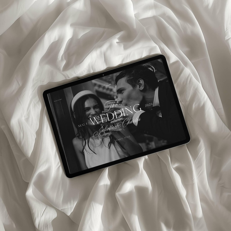 May include: A black and white image of a tablet displaying a wedding photo. The tablet is on a white, textured surface. The photo features a couple, with the text "The Wedding" and names. The date "2026" is also visible.