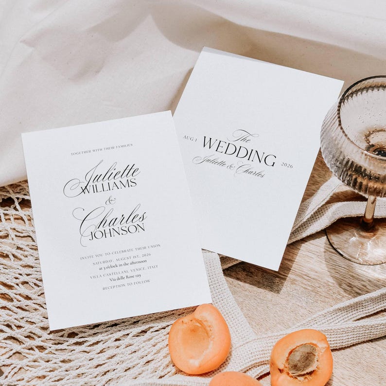 May include: Two white wedding invitation cards with elegant script. One card reads "Juliette Williams & Charles Johnson" and the other says "The Wedding Juliette & Charles 2026". Apricots and a champagne glass are also in the image.