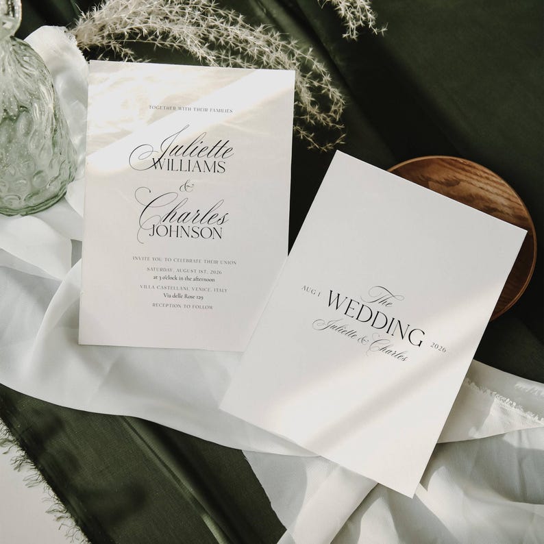 May include: Two white wedding invitation cards with elegant calligraphy. The first card reads "Juliette Williams & Charles Johnson" and includes event details. The second card says "The Wedding" and the names "Juliette & Charles".