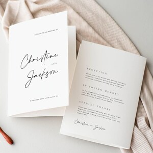 May include: Two white wedding invitation cards with black text. The front card reads "WELCOME TO THE WEDDING OF" followed by the names "Christine" and "Jackson" in elegant script. The date and location are also printed.