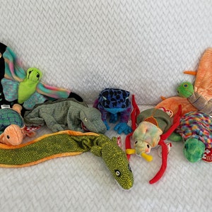 Puede incluir: Una colección de nueve peluches coloridos, incluyendo una mariposa, una rana, una tortuga, un lagarto y una serpiente. Los juguetes están hechos de tela suave y acogedora y tienen colores brillantes y alegres.