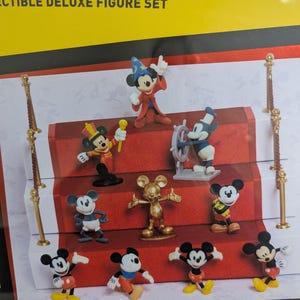 Puede incluir: Un juego de figuras de lujo coleccionables con varias figuras de Mickey Mouse en diferentes poses y atuendos. Las figuras est&aacute;n dispuestas sobre una pantalla de alfombra roja con detalles dorados. El juego incluye una figura de Mickey Mouse dorada.