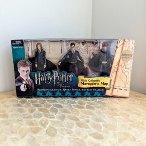 May include: A boxed set of three Harry Potter and the Order of the Phoenix action figures featuring Hermione Granger, Harry Potter, and Ron Weasley. The packaging includes a collectible Marauder's Map and a Borders exclusive sticker on the front.