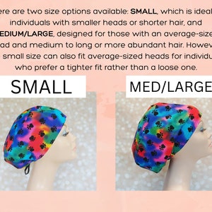 May include: Two surgical caps with a paw print pattern on a rainbow background. The cap on the left is labeled "SMALL" and the cap on the right is labeled "MED/LARGE".
