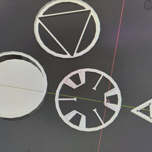Può includere: Quattro stencil in plastica bianca, due sono cerchi con disegni diversi, uno è un triangolo e uno è un cerchio più grande.