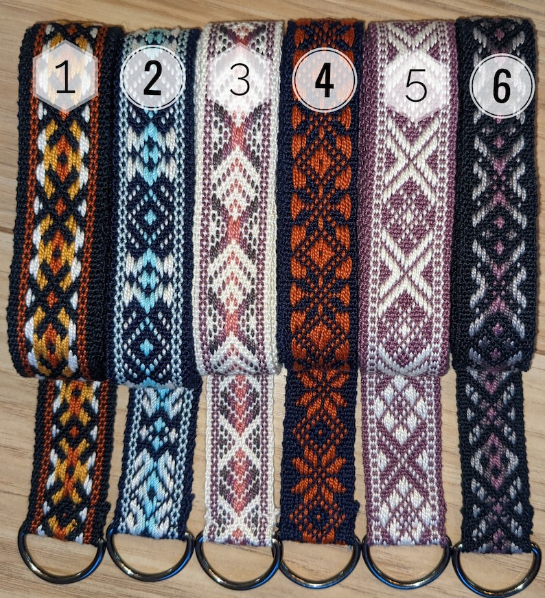 May include: Six different woven straps with various geometric patterns in colors like orange, blue, pink, and purple. Each strap has a metal ring attached.