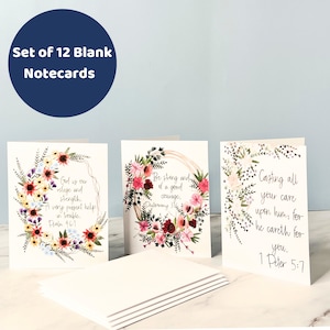 May include: Set of 12 blank notecards with floral designs and inspirational quotes. The quotes are: "God is our refuge and strength. A very present help in trouble. Psalm 46:1", "Be strong and of a good courage, Deuteronomy 31", and "Casting all your care upon him, for he careth for you. 1 Peter 5:7".