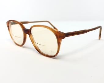May include: Brown tortoise shell eyeglasses with clear lenses. The glasses have a simple, classic design.
