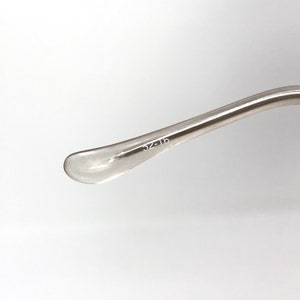 May include: Close-up of a clear eyeglass temple arm with the text "52-16" printed on the arm. The arm is curved and has a clear, rounded tip. The background is white.