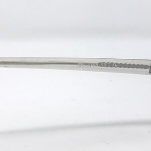 May include: Close-up of a clear eyeglass frame arm with the text "MC-1190 52 16" printed on it. The frame is made of a transparent material and is set against a white background.