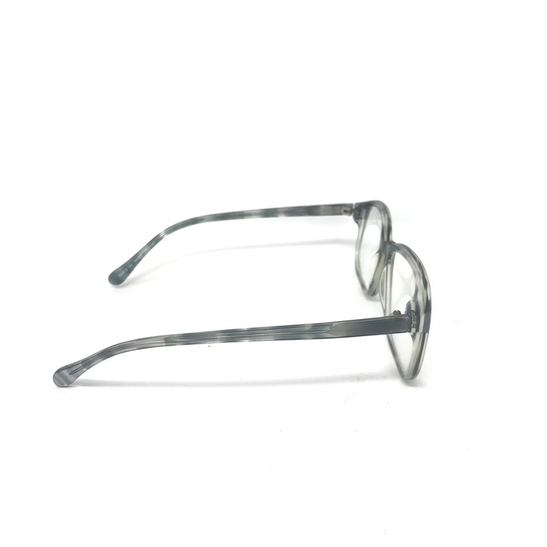 Puede incluir: Gafas grises con un patr&oacute;n veteado. Las monturas tienen forma redondeada y lentes transparentes. Las patillas son finas y se extienden hasta las orejeras. Las gafas est&aacute;n sobre un fondo blanco.