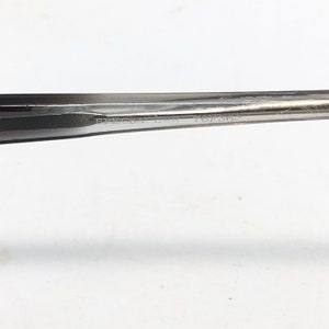 Op de afbeelding: Close-up van een zilveren metalen gereedschap met de tekst "SPECIA LBR 76F362" ge&euml;tst op het oppervlak. Het gereedschap heeft een taps toelopend ontwerp en lijkt te worden gebruikt voor precisiewerk. De achtergrond is wit.