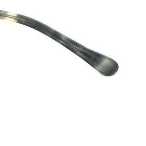 May include: Close-up of a gray and tan eyeglasses arm. The arm has a rounded tip and a subtle pattern. The text "OPPEL RAY" is visible on the arm.