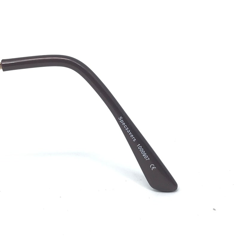 May include: Close-up of a dark brown eyeglass arm. The text "Specsavers 1000907 CE" is printed in white on the arm. The arm curves gently and ends in a rounded tip.
