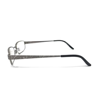 May include: Gray metal eyeglasses with a rectangular frame and black temples. The temples feature a decorative etched pattern. The lenses are clear. The glasses are designed for vision correction.