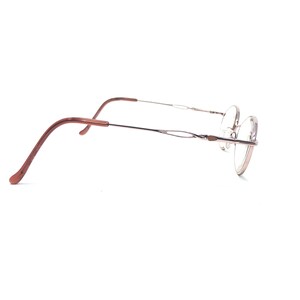 K&ouml;nnte beinhalten: Eine Brille mit einem d&uuml;nnen, silbernen Rahmen und runden Gl&auml;sern. Die B&uuml;gel sind dunkelbraun. Die Brille ist vor einem wei&szlig;en Hintergrund platziert.