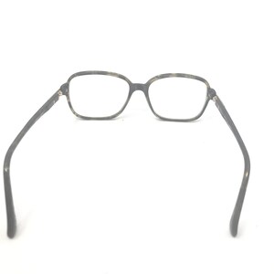 Puede incluir: Gafas rectangulares con montura de carey. Las lentes transparentes est&aacute;n enmarcadas y las patillas son de color gris oscuro. Las gafas est&aacute;n sobre un fondo blanco.