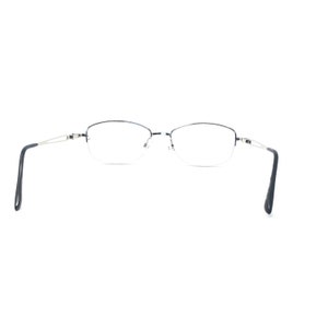 May include: Rimless eyeglasses with a silver frame and dark blue temples. The lenses are a classic oval shape. The glasses are set against a white background.