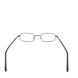 Puede incluir: Gafas rectangulares negras con lentes transparentes. Las gafas tienen una montura y patillas finas y oscuras que se extienden hacia afuera. Las almohadillas nasales son de color amarillo claro.