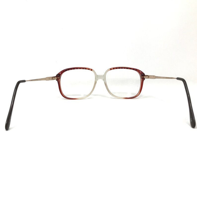 K&ouml;nnte beinhalten: Braune und silberne Brille mit rechteckigem Gestell.