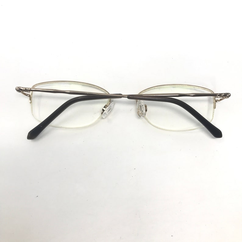 May include: A pair of silver-toned eyeglasses with black arms and clear lenses.