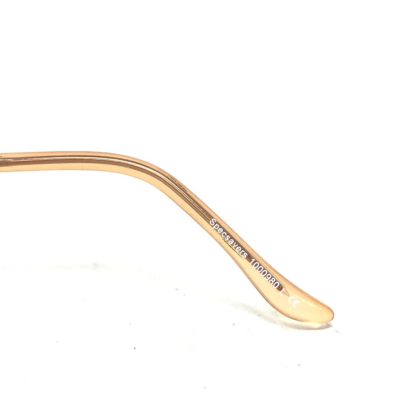 Op de afbeelding: Close-up van de gouden arm van een bril met de tekst "Specsavers 1000980-1 CE" erop gedrukt.