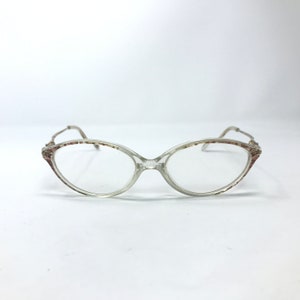May include: Clear plastic oval-shaped eyeglasses with a brown and white patterned frame.