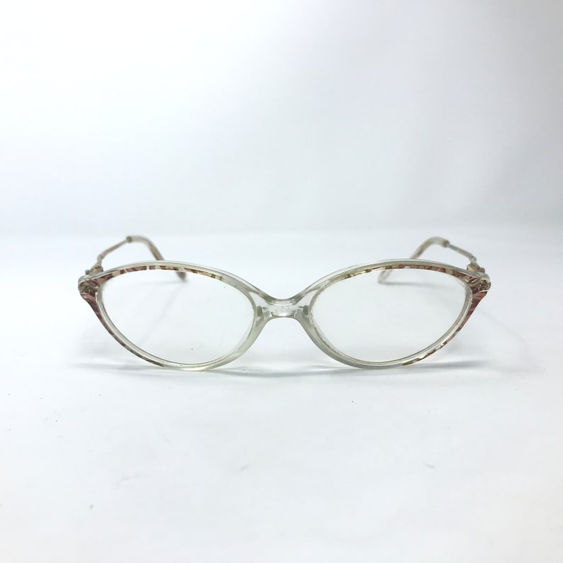 May include: Clear plastic oval-shaped eyeglasses with a brown and white patterned frame.
