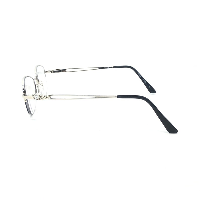 May include: Silver-toned eyeglasses with a delicate, geometric design at the temples. The frames have a thin, wire-like appearance, with black temple arms. The lenses are clear, and the overall style is minimalist and modern.