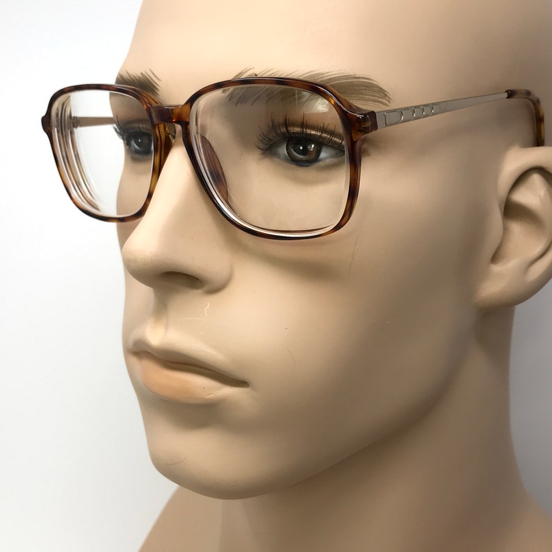 K&ouml;nnte beinhalten: Eine Brille mit Schildpatt-Gestell, klaren Gl&auml;sern und einem silbernen Metallrahmen.