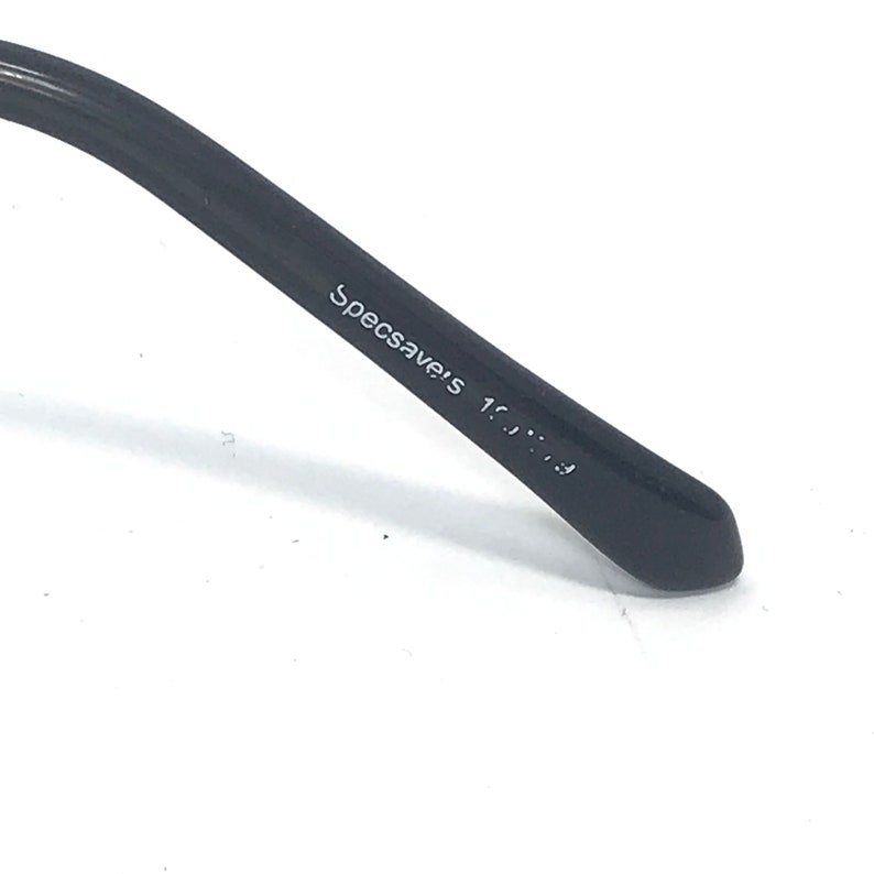 May include: Close-up of the black arm of a pair of glasses with the text "Specsavers 1.5..." printed on the arm.