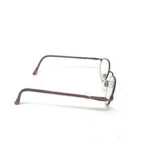 Puede incluir: Un par de gafas con una montura fina y ovalada. Las patillas son de color p&uacute;rpura apagado y la montura es de color oscuro y met&aacute;lico. Las lentes son transparentes y se ven las almohadillas nasales.