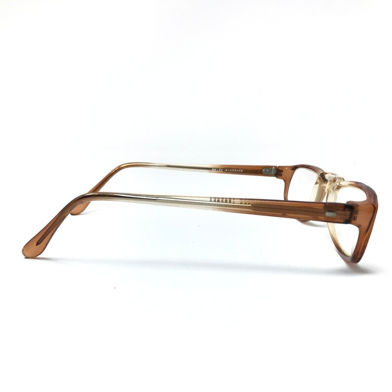May include: Brown plastic framed eyeglasses with clear lenses. The frames have a gradient color, fading from a darker brown to a lighter brown.