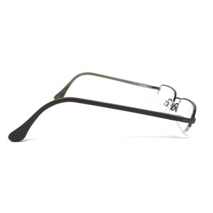 K&ouml;nnte beinhalten: Halbrandlose Brille mit dunkelbraunem Rahmen und B&uuml;geln. Die Gl&auml;ser sind klar, und die Nasenpads sind sichtbar. Die Brille ist vor einem wei&szlig;en Hintergrund platziert.