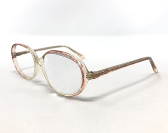 May include: Clear-framed spectacles with an oval shape. The frames feature a reddish-brown pattern around the lenses and on the arms. These glasses are designed for vision correction and are suitable for daily wear.