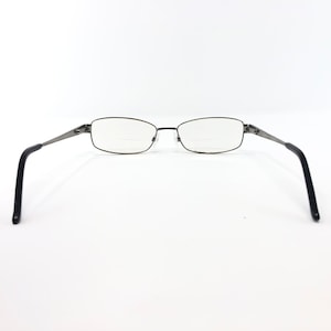 May include: Rectangular eyeglasses with a dark metal frame and black temples. The lenses have a bifocal design. The glasses are set against a white background.