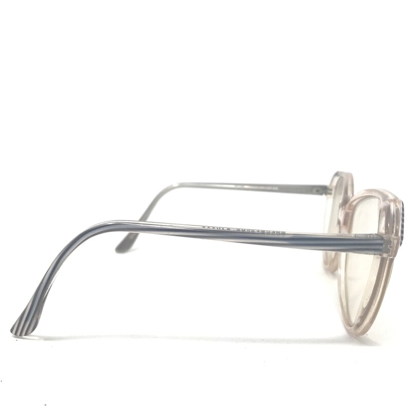May include: A pair of eyeglasses with a light pink frame and silver arms. The arms have a striped pattern near the ear. The lenses are clear. The glasses are set against a white background.
