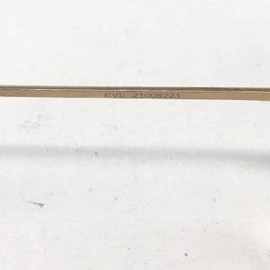 Pu&ograve; includere: Primo piano di una barra di metallo dorata con il testo "EVL 21008221" inciso su di essa.