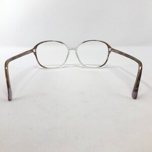 May include: Clear eyeglasses with a light brown and purple speckled pattern on the frame. The glasses have a classic, rectangular shape and are set against a white background.