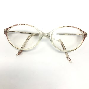 May include: Clear oval-shaped eyeglasses with a brown and white patterned frame.