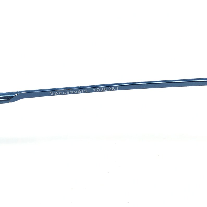May include: Close-up of a section of blue eyeglasses frame. The text "Specsavers" and the number "1036361" are printed on the frame. The frame is a thin, sleek design, likely made of metal, with a modern aesthetic.
